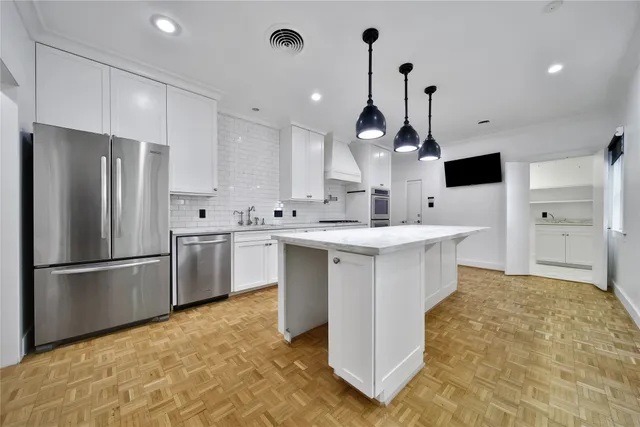 a kitchen with kitchen island a sink stainless steel appliances and cabinets