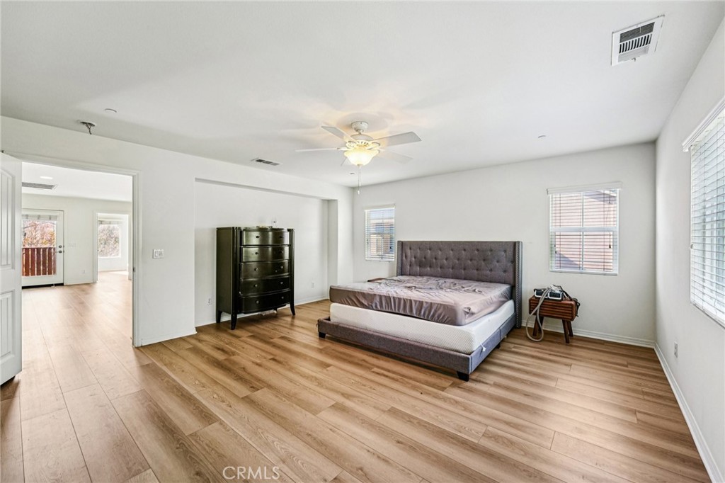 12936 Canopy Court Rancho Cucamonga, CA 91739 - Photo 16 of 32 a spacious bedroom with a bed and a wooden floor