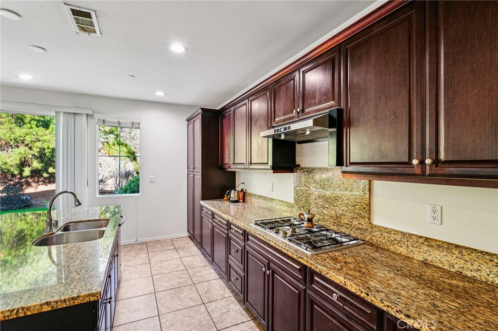 12936 Canopy Court Rancho Cucamonga, CA 91739 - Photo 7 of 32 a kitchen with stainless steel appliances granite countertop a stove and a refrigerator