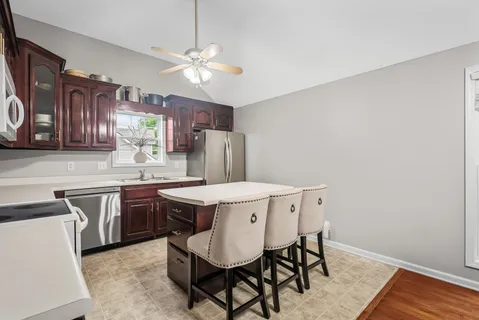 a kitchen with a table chairs sink and cabinets