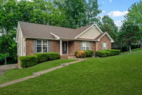 a front view of a house with yard and green space