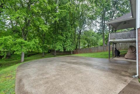 a view of a house with a big yard and large trees