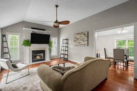 a living room with furniture a fireplace and a flat screen tv