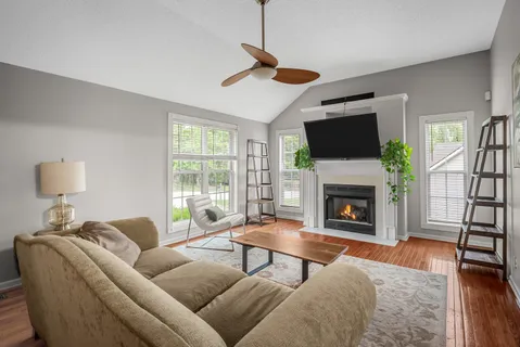 a living room with furniture a fireplace and a flat screen tv