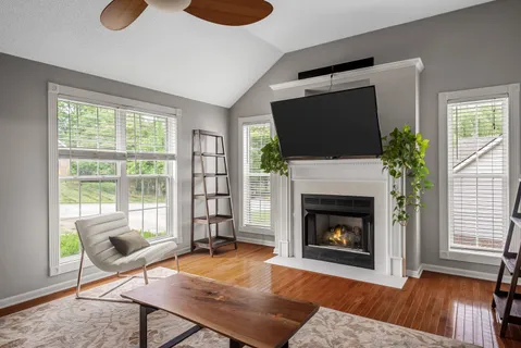 a living room with furniture a flat screen tv and a fireplace