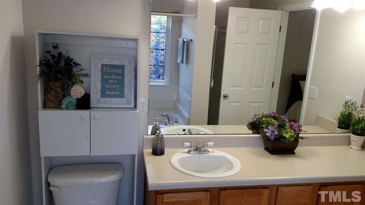 2304 Spruce Shadows Lane Raleigh, NC 27614 - Photo 12 of 25 a bathroom with a sink toilet and mirror