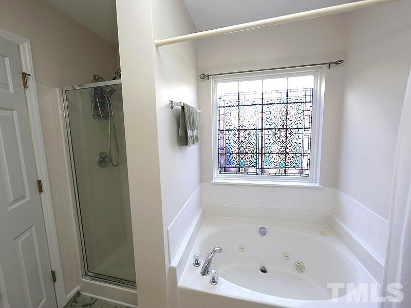 2304 Spruce Shadows Lane Raleigh, NC 27614 - Photo 13 of 25 a white bath tub sitting in a bathroom next to a window