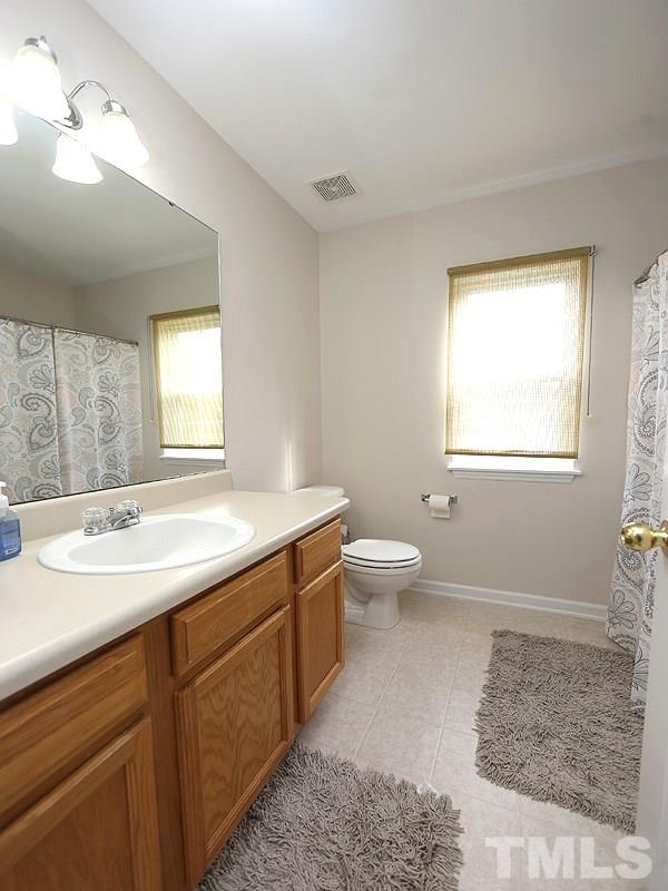 2304 Spruce Shadows Lane Raleigh, NC 27614 - Photo 14 of 25 a spacious bathroom with a toilet sink and mirror