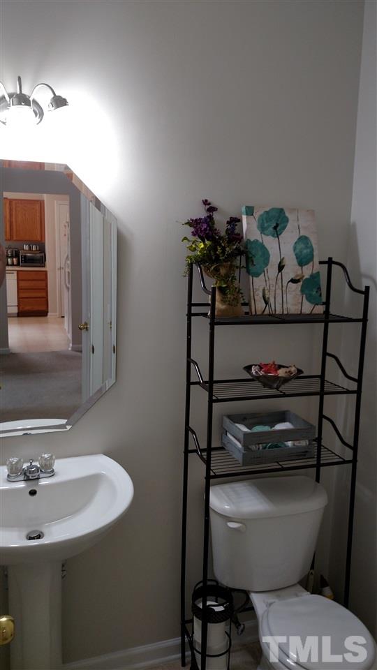 2304 Spruce Shadows Lane Raleigh, NC 27614 - Photo 6 of 25 a bathroom with a sink toilet and mirror
