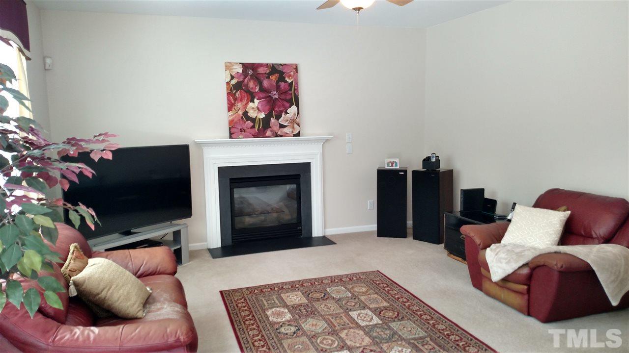2304 Spruce Shadows Lane Raleigh, NC 27614 - Photo 8 of 25 a living room with furniture a flat screen tv and a fireplace