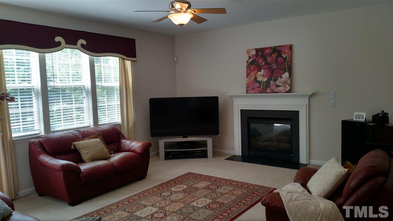 2304 Spruce Shadows Lane Raleigh, NC 27614 - Photo 9 of 25 a living room with furniture a flat screen tv and a fireplace