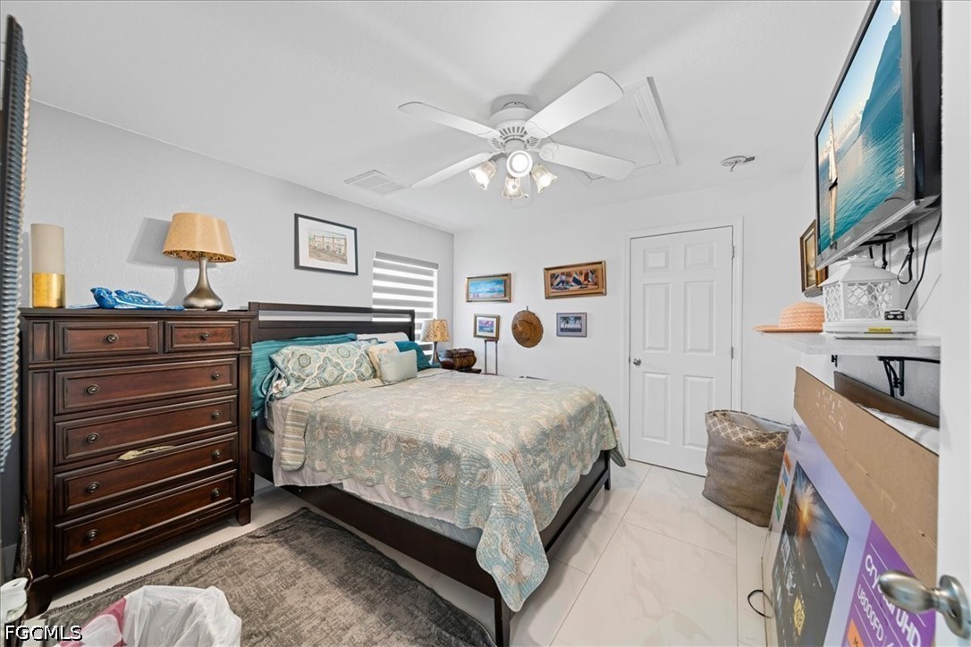 22 Nelson Road South Cape Coral, FL 33991 - Photo 23 of 43 a bed room with a bed and a chandelier