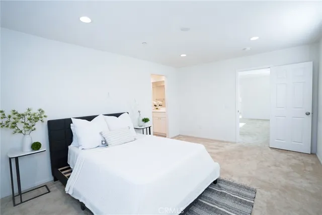 a spacious bedroom with a bed and a potted plant