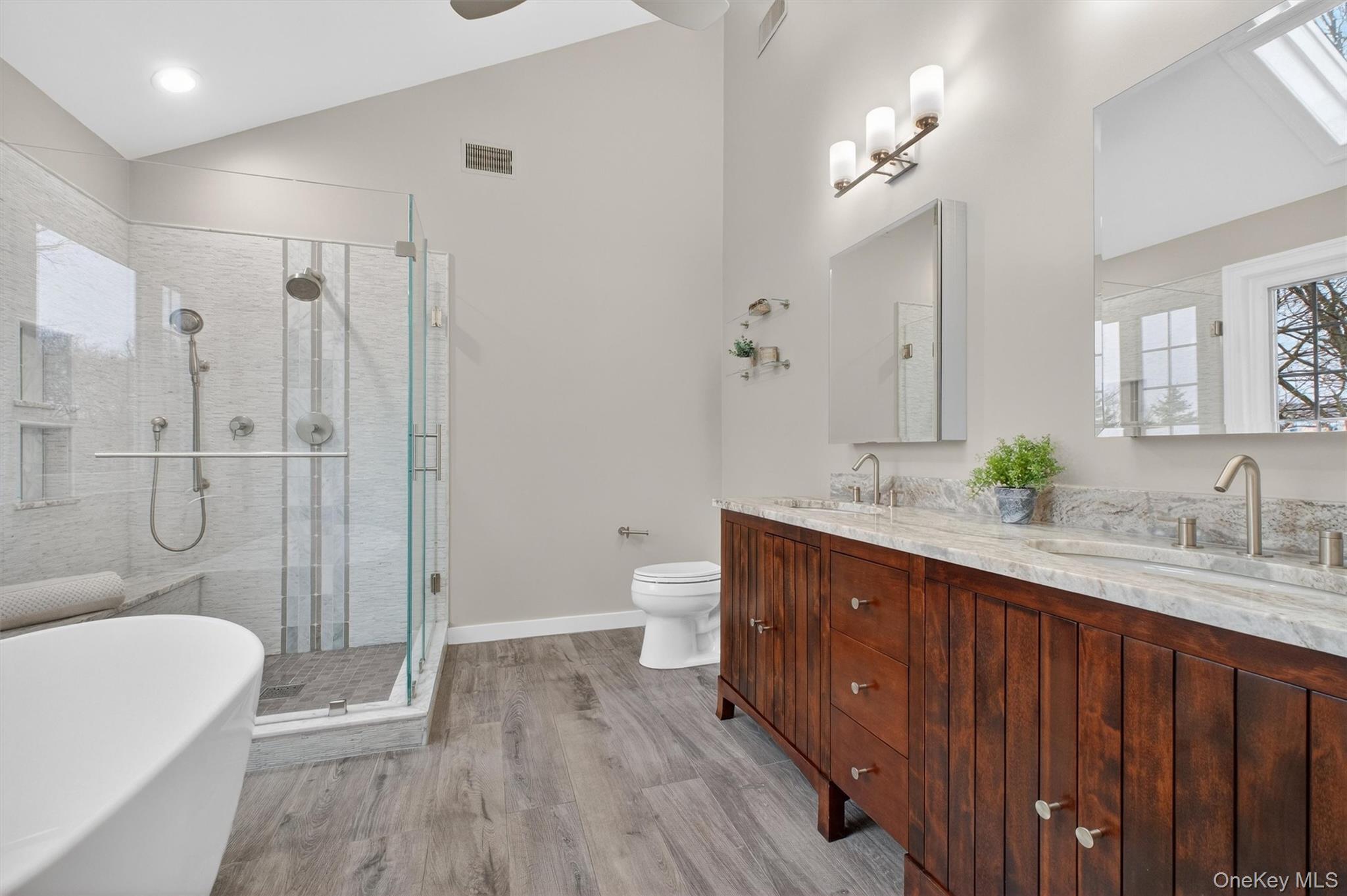 45 East Hill Road Cortlandt Manor, NY 10567 - Photo 19 of 48 a spacious bathroom with a double vanity sink a toilet a shower and a mirror