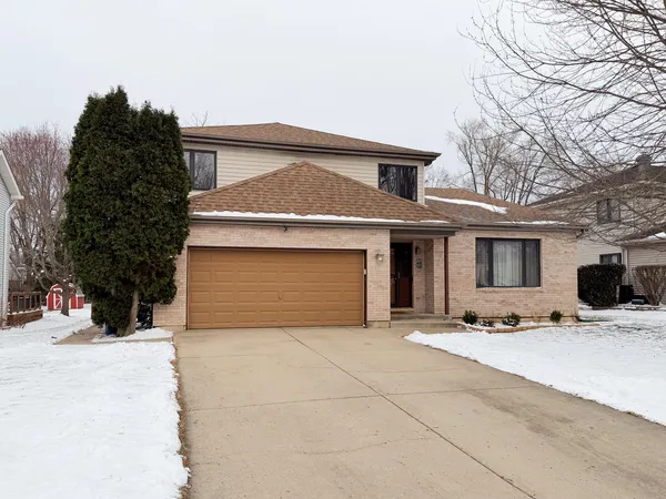 a front view of a house with yard and garage