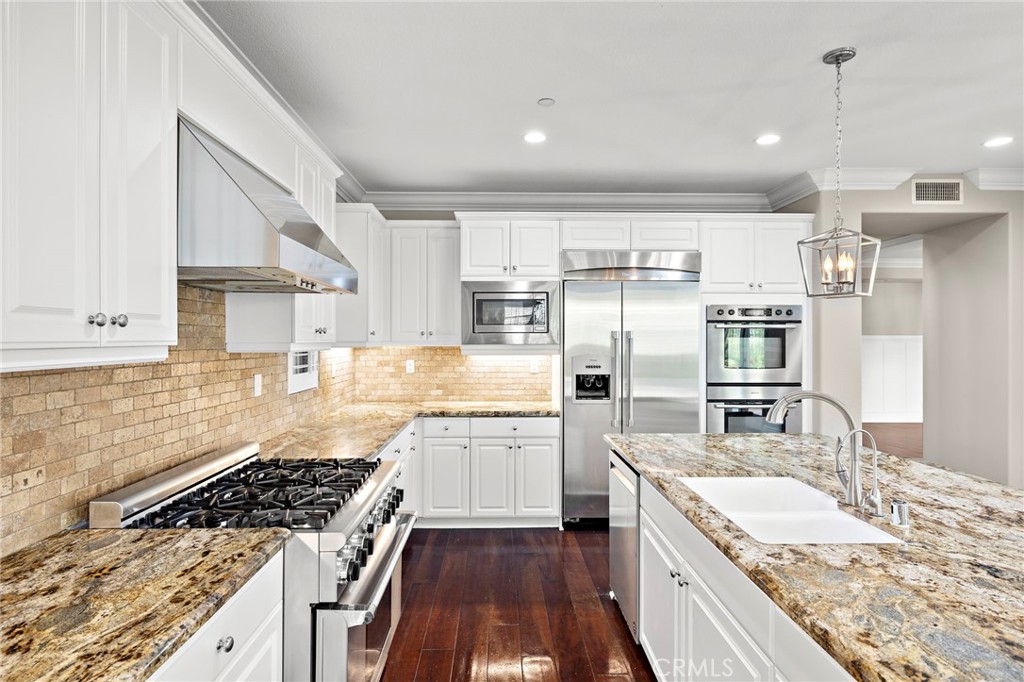 3 Eric Street Ladera Ranch, CA 92694 - Photo 11 of 35 a large kitchen with stainless steel appliances granite countertop a large stove a sink dishwasher and refrigerator with wooden floor