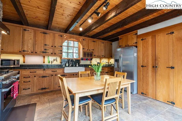 a dining table with chairs and kitchen view