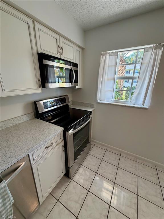 3325 Airport Road North, Unit N3 Naples, FL 34105 - Photo 5 of 12 a kitchen with stainless steel appliances a sink stove and microwave