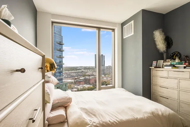 a bedroom with a bed and a large window