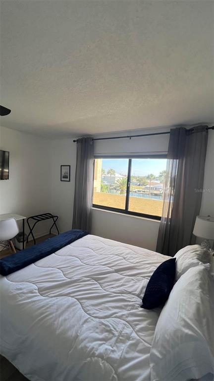 6035 Sea Ranch Drive, Unit 211 Hudson, FL 34667 - Photo 13 of 21 a bedroom with a large window and a bed