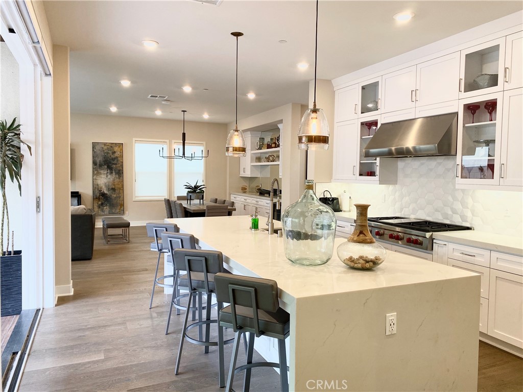 62 Hawking Irvine, CA 92618 - Photo 4 of 37 a kitchen with stainless steel appliances kitchen island granite countertop a stove a refrigerator a kitchen island a dining table and chairs