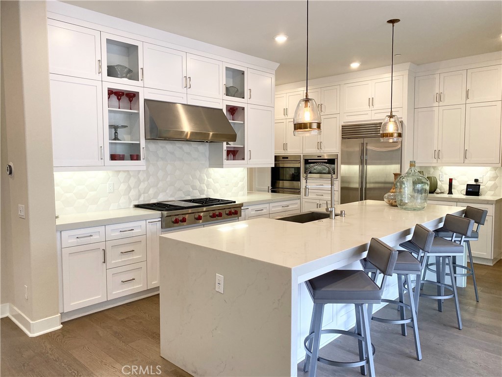 62 Hawking Irvine, CA 92618 - Photo 7 of 37 a kitchen with stainless steel appliances kitchen island granite countertop a table chairs and a view of living room