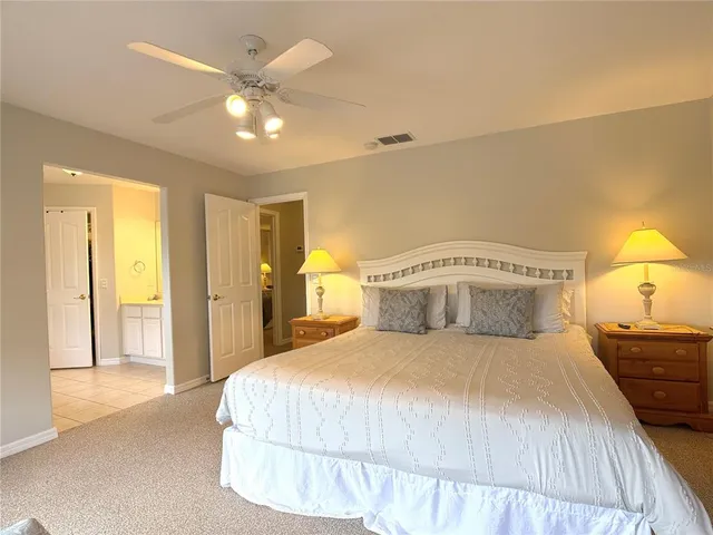 a bedroom with a large bed and a chandelier