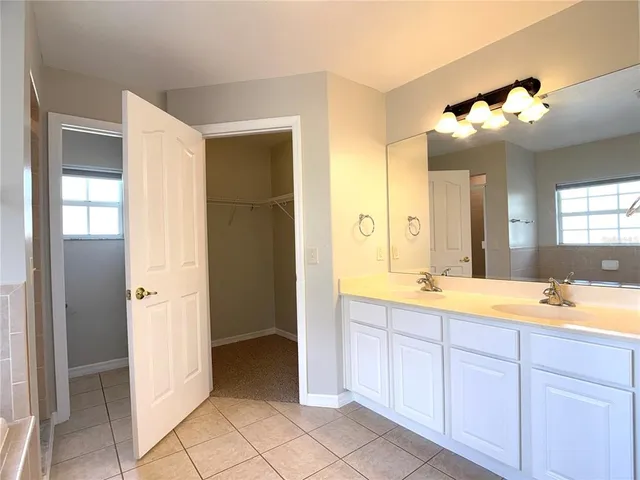 a spacious bathroom with a double vanity sink mirror and shower