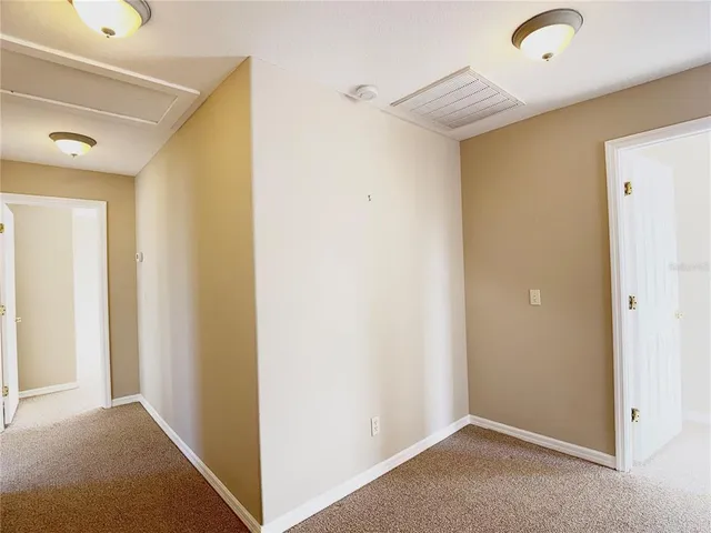 an empty room with windows and ceiling fan