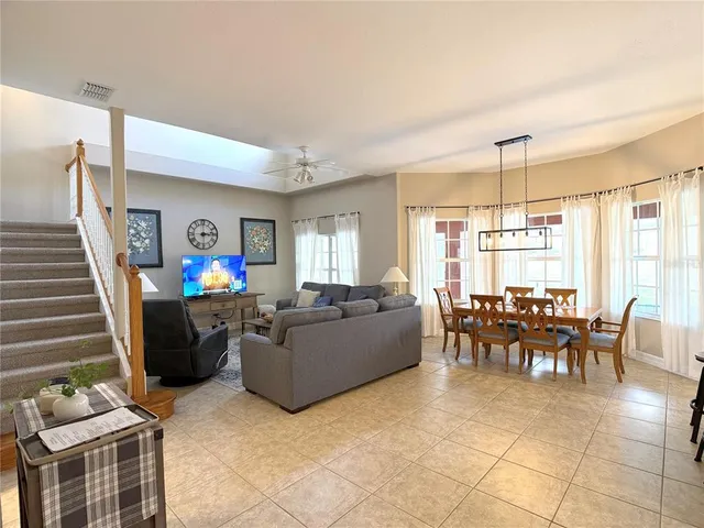 a living room with furniture and a dining table with kitchen view