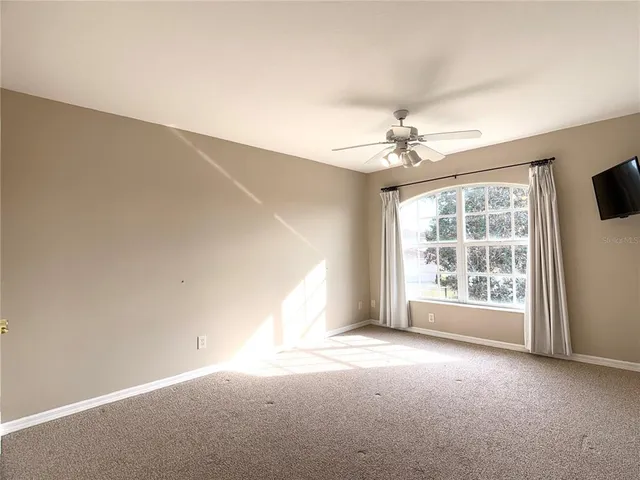 a view of empty room with a ceiling fan