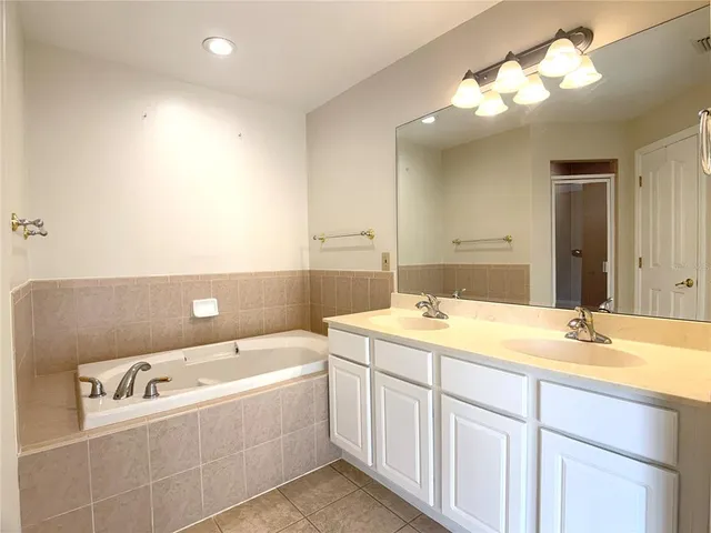 a bathroom with a tub sink and mirror
