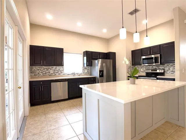 a kitchen with stainless steel appliances a refrigerator sink and microwave