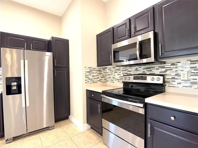 a kitchen with stainless steel appliances granite countertop a stove microwave and refrigerator