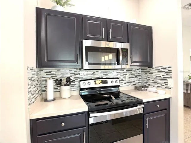 a kitchen with stainless steel appliances a stove microwave and sink