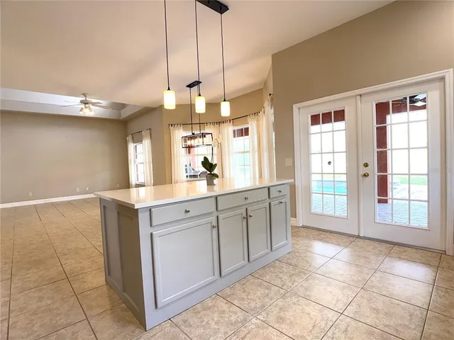 a large kitchen with kitchen island granite countertop a large window and a rug