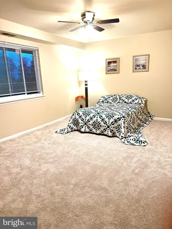 a bedroom with a bed and painting on the wall