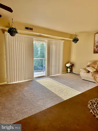 a living room with a stove a sink and a kitchen island with large windows