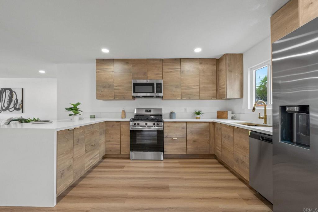 508 Village View Place Fallbrook, CA 92028 - Photo 4 of 32 a large kitchen with stainless steel appliances granite countertop a stove a sink dishwasher and a microwave oven with white cabinets