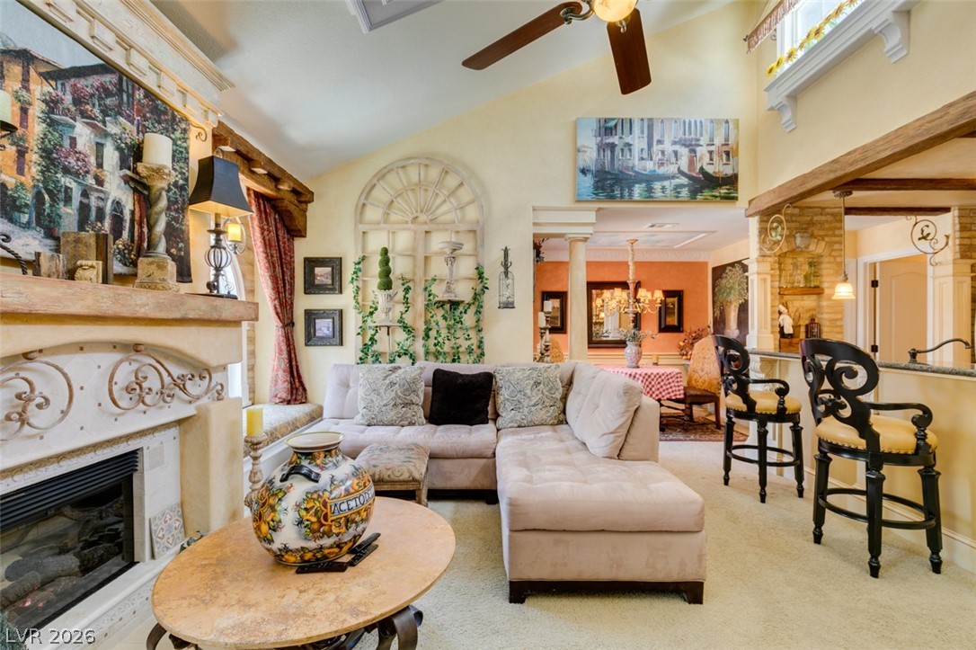 9325 West Desert Inn Road, Unit 244 Las Vegas, NV 89117 - Photo 13 of 55 A spacious living room features vaulted ceilings, a cozy fireplace, and an elegant bar area.
