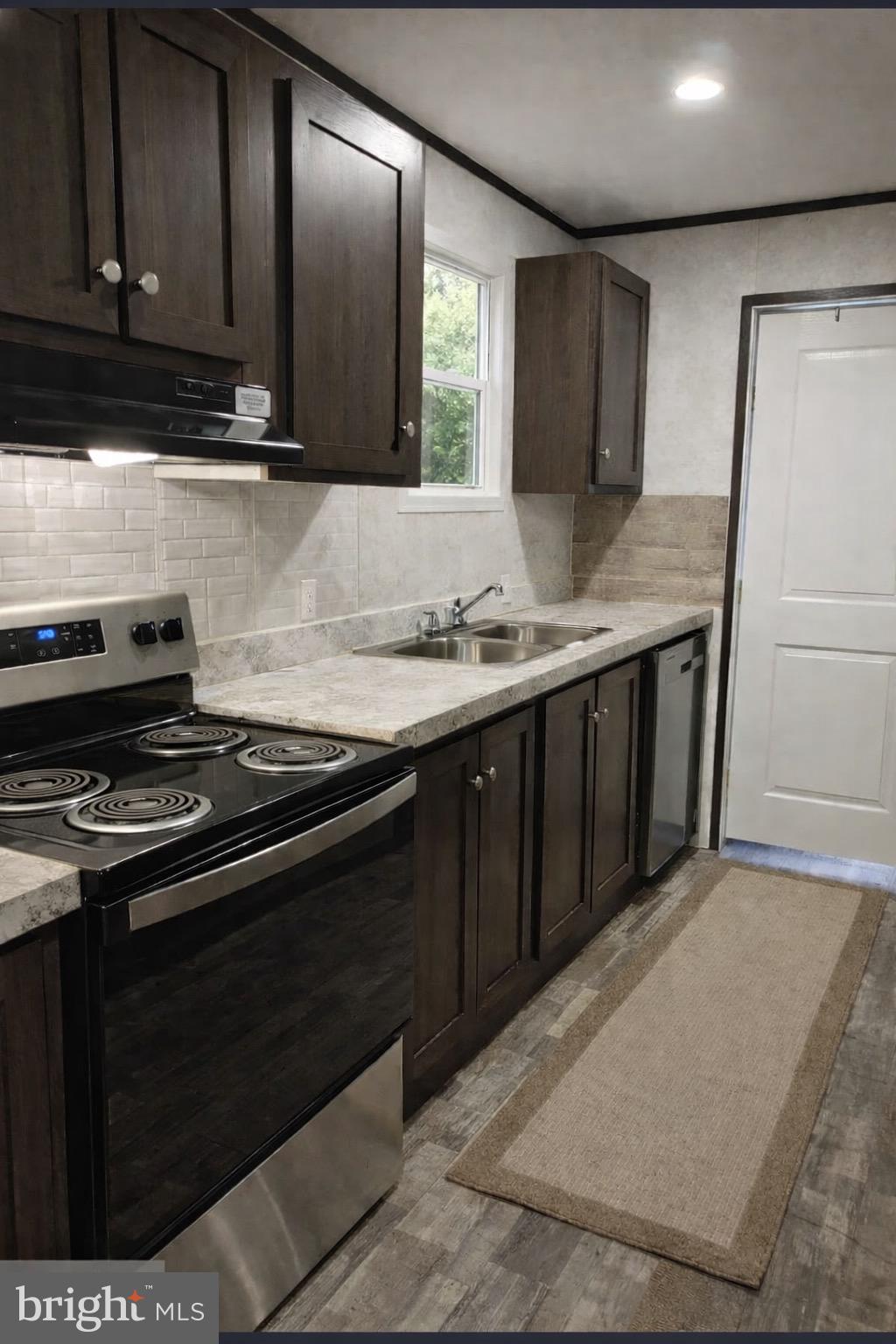 1446 Gibson Road, Unit D50 Bensalem, PA 19020 - Photo 2 of 8 a kitchen with stainless steel appliances granite countertop a stove a sink and a microwave