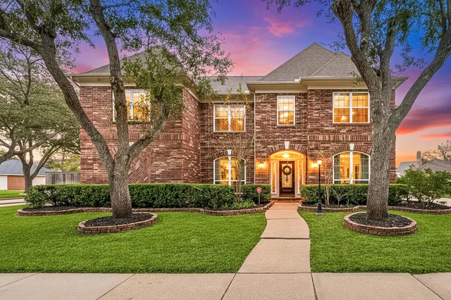 a front view of a house with yard and green space