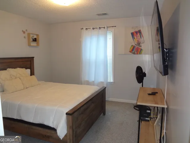 a bedroom with a bed and a tv