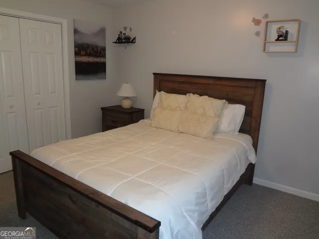 a bedroom with a bed a flat screen tv and wall