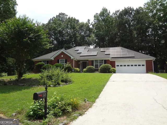 a view of a house with a yard and potted plants