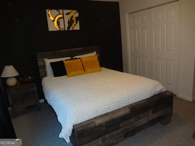 a bedroom with a bed and a flat tv screen on dresser