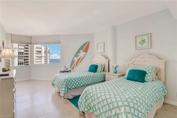 a bedroom with two beds and a window