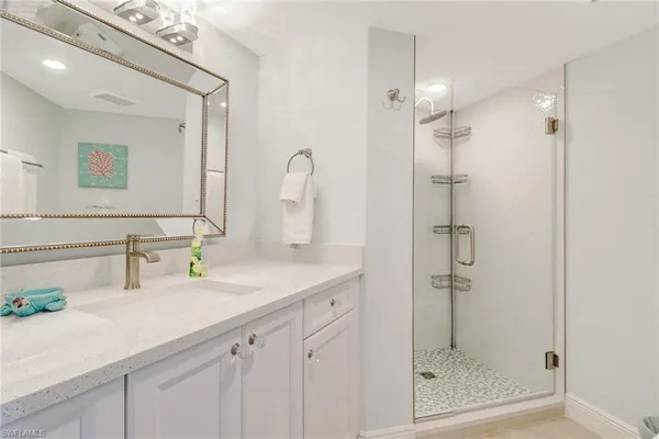 a bathroom with a shower sink and mirror