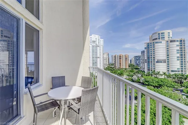 a view of a city from a balcony with furniture