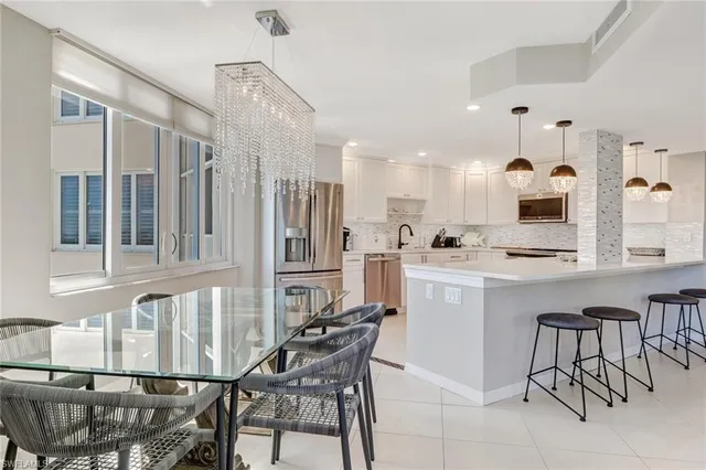 a kitchen with a dining table chairs appliances and cabinets